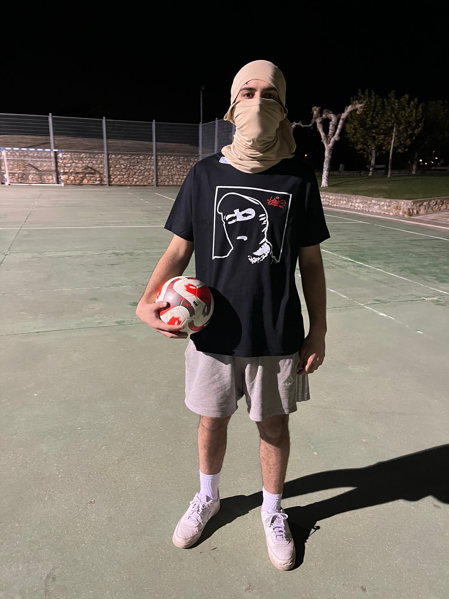 Camiseta Cara Tapada de Kheis – vista completa en exterior nocturno