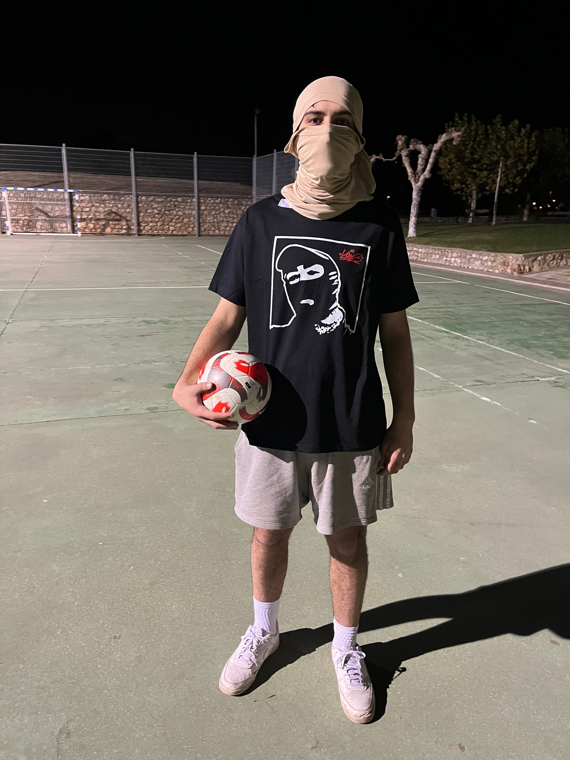 Camiseta Cara Tapada de Kheis – vista completa en exterior nocturno